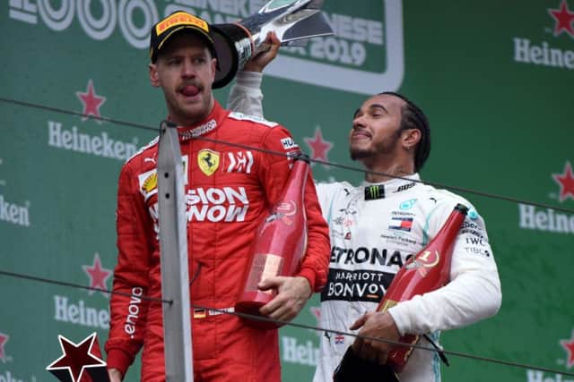 Lewis Hamilton celebrates with the trophy but Sebastian Vettel edured a difficult afternoon. Picture: AFP/Getty