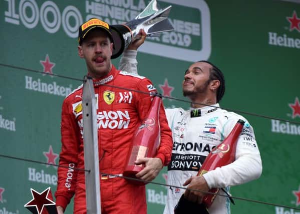 Lewis Hamilton celebrates with the trophy but Sebastian Vettel edured a difficult afternoon. Picture: AFP/Getty