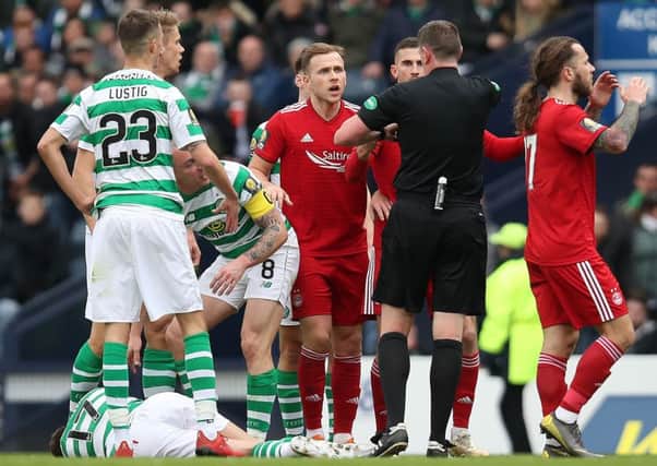 Referee Craig Thomson shows a red card to Dominic Ball as Ryan Christie lies injured on the turf. Picture: Getty