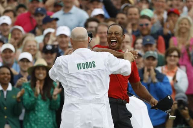 Tiger Woods celebrates  with his caddie, Joe LaCava, at Augusta on Sunday.