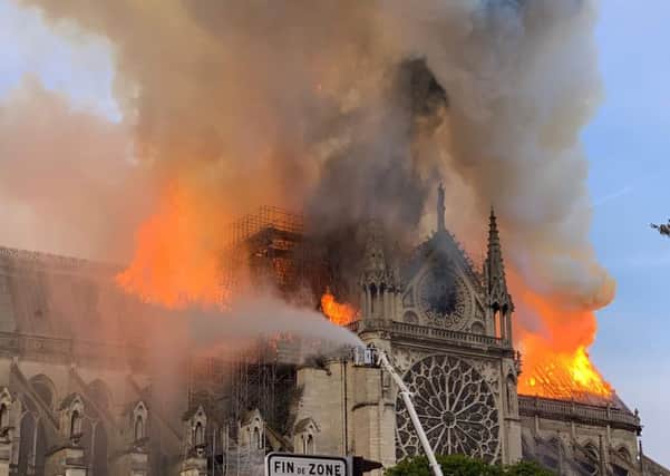 Flames and smoke are seen billowing from the roof at Notre-Dame Cathedral in Paris on April 15, 2019. (Photo by Patrick ANIDJAR / AFP)