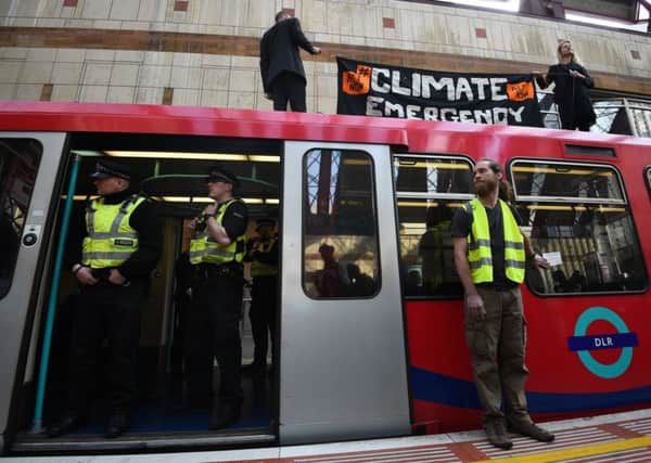 Climate activists on top of a Dockland Light Railway train at Canary Wharf station in east London. Picture: Kirsty O'Connor/PA Wire