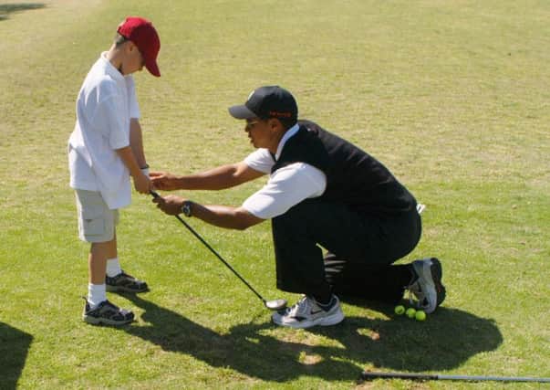 Tiger Woods teaches an eight-year-old budding golfer at his clinic. Now, following his victory in the Masters, junior sessions at clubs around the world are expected to experience a surge in youngsters taking up the sport. Picture: Getty.