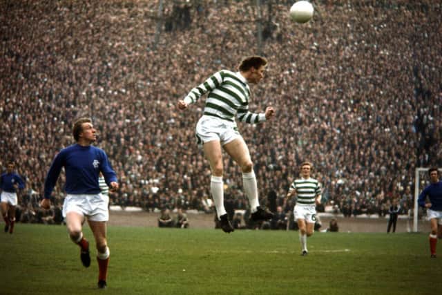 Rangers' Colin Stein looks on as Billy McNeill rises to meet a high ball. Celtic eventually won after a replay.