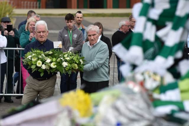 Former team-mates Bertie Auld and John Clark pay tribute to Billy McNeill at his statue outside Celtic Park. Picture: Jeff J Mitchell/Getty