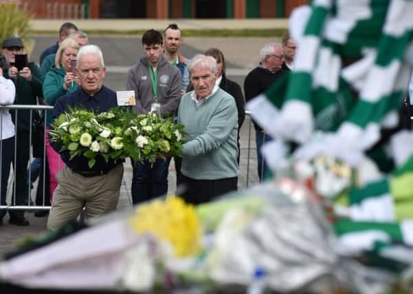 Former team-mates Bertie Auld and John Clark pay tribute to Billy McNeill at his statue outside Celtic Park. Picture: Jeff J Mitchell/Getty