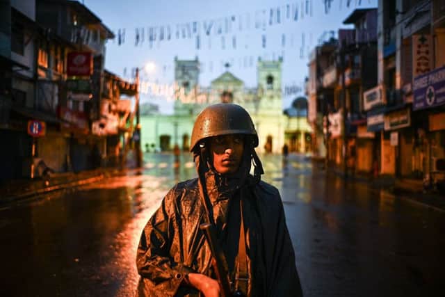 A Sri Lankan soldier stands guard under the rain at St. Anthony's Shrine in Colombo on April 25, 2019, following a series of bomb blasts targeting churches and luxury hotels on the Easter Sunday in Sri Lanka. - Sri Lanka's Catholic church suspended all public services over security fears on April 25, as thousands of troops joined the hunt for suspects in deadly Easter bombings that killed nearly 360 people. (Photo by Jewel SAMAD / AFP)JEWEL SAMAD/AFP/Getty Images