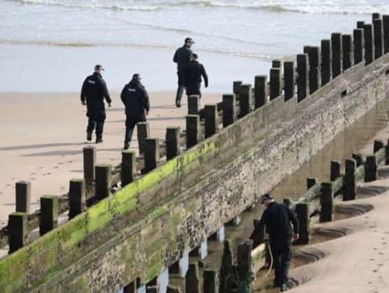 Police examining the beach where the women died. Picture: PA