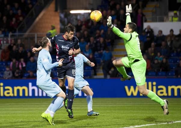 Brian Graham heads past Queen of the South keeper Deniz Mehmet to complete Ross Countys 4-0 victory. Picture: SNS.