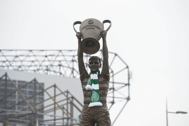 The statue of Billy McNeill is adorned with tributes, with Celtic Park stadium in the background. Picture: SNS Group