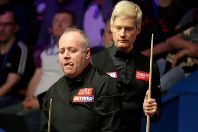 Neil Robertson keeps an eye on John Higgins, front, as the Scot contemplates a shot. Picture: Richard Sellers/PA Wire