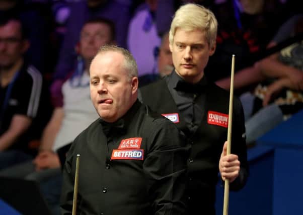 Neil Robertson keeps an eye on John Higgins, front, as the Scot contemplates a shot. Picture: Richard Sellers/PA Wire
