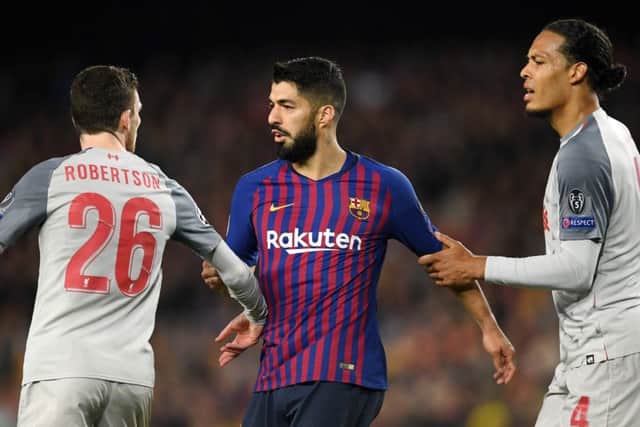 Andy Robertson (left) with Luis Suarez of Barcelona as Virgil van Dijk tries to break them apart. Picture: Getty Images
