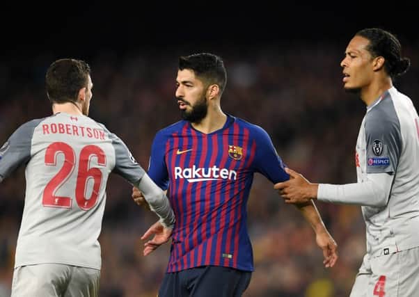 Andy Robertson (left) with Luis Suarez of Barcelona as Virgil van Dijk tries to break them apart. Picture: Getty Images