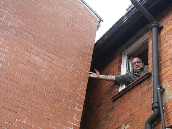 Mr Robinson says he can reach out and touch is neighbour's extension from his window with the property hampering efforts to sell his own home.
