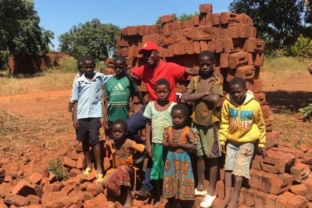 Everson Mapayani, Malawis youngest councillor at 28, with some young helpers, as he collects bricks to build a youth and childrens centre (Picture: Susan Dalgety)