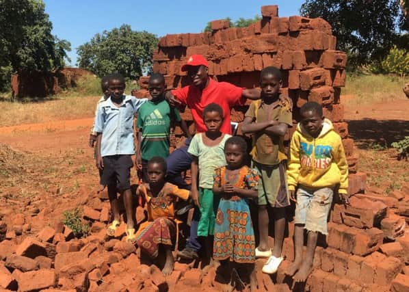 Everson Mapayani, Malawis youngest councillor at 28, with some young helpers, as he collects bricks to build a youth and childrens centre (Picture: Susan Dalgety)