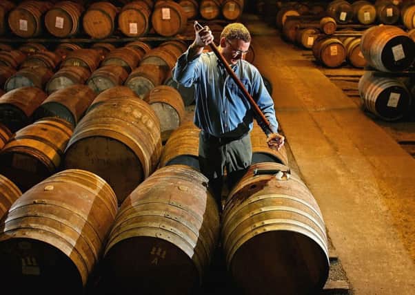 A worker at Bruichladdich distillery in Islay takes a whisky sample from a cask. Picture: Getty