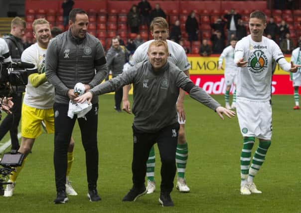 Neil Lennon celebrates steering his side to the title with his players and backroom staff. Picture: SNS.