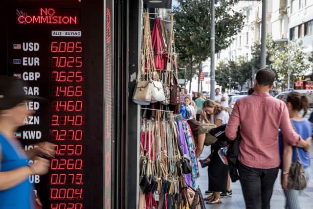 ISTANBUL, TURKEY - AUGUST 14: People walk past a currency exchange shop on August 14, 2018 in Istanbul, Turkey. The Turkish Lira recovered slightly Tuesday after the previous days heavy losses helped by the news that Finance Minister Berat Albayrak will hold a conference call Thursday to reassure investors and the central banks liquidity measures. In a speech in Ankara Turkish President Recep Tayyip Erdogan threatened to boycott U.S. electrical goods including the iPhone in response to U.S. sanctions continuing tensions between the two countries. (Photo by Chris McGrath/Getty Images)
