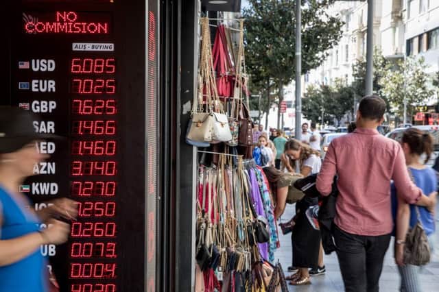 ISTANBUL, TURKEY - AUGUST 14:  People walk past a currency exchange shop on August 14, 2018 in Istanbul, Turkey. The Turkish Lira recovered slightly Tuesday after the previous days heavy losses helped by the news that Finance Minister Berat Albayrak will hold a conference call Thursday to reassure investors and the central banks liquidity measures. In a speech in Ankara Turkish President Recep Tayyip Erdogan threatened to boycott U.S. electrical goods including the iPhone in response to U.S. sanctions continuing tensions between the two countries.  (Photo by Chris McGrath/Getty Images)
