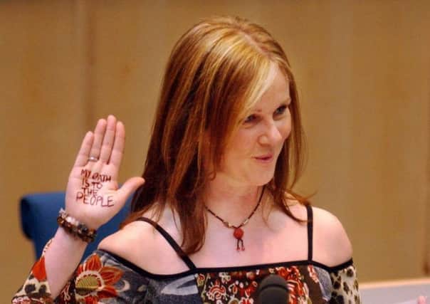 Rosie Kane, one of six Scottish Socialist Party MSPs returned at the 2003 election, swears her oath with the words 'My oath is to the people' written on her palm. Picture: PA