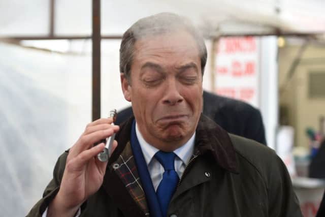 Brexit Party leader Nigel Farage coughs as he samples a Pinkman flavoured e-cigarette during a Brexit Party walkabout in Lincoln. Picture: Joe Giddens/PA Wire