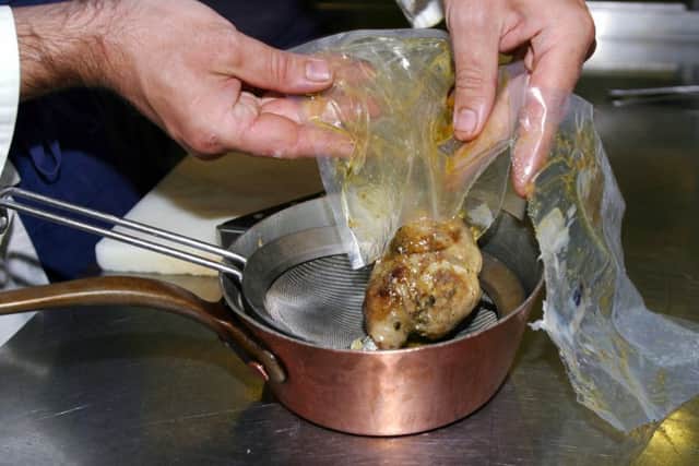Thierry Mechinaud, a sous chef at Michelin three-star restaurant Pierre Gagnaire, removes pheasant with a pistachio stuffing from the vacuum-sealed bag in which it was slow-cooked at a very low temperature. Pic:  JOE RAY/AFP/Getty Images