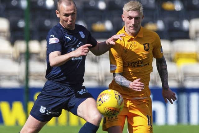 Dundee's Kenny Miller competes with Livingston's Craig Sibbald. Pic: SNS/Ross MacDonald
