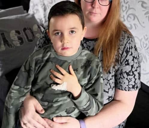Rhys Pringles showing his bandaged finger with mum Arlene.  Picture: SWNS
