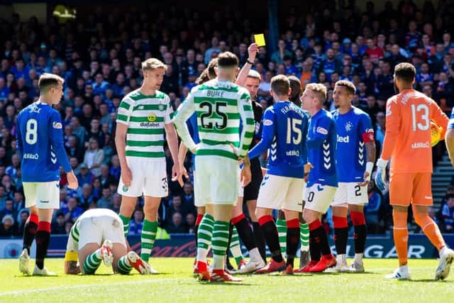 Referee Kevin Clancy books Rangers' Jon Flanagan after a clash with Celtic's Scott Brown. Picture: SNS