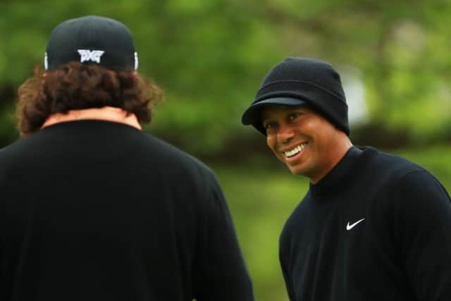 A relaxed looking Tiger Woods shares a joke with fellow American golfer Pat Perez on the practice green at the Bethpage Black course. Picture: Getty