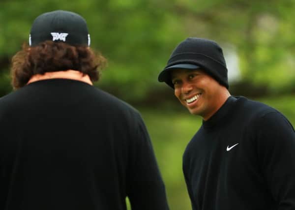 A relaxed looking Tiger Woods shares a joke with fellow American golfer Pat Perez on the practice green at the Bethpage Black course. Picture: Getty