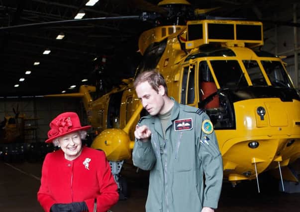 Prince William with his grandmother the Queen during his time as an air ambulance pilot. Picture: Getty