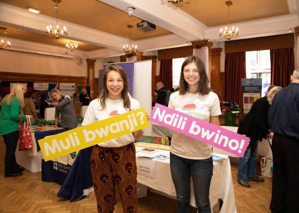 Chiara Cotronei and Nicola Goldmann, both SMP youth committee members, holding signs in Chichewa, saying . Muli Bwanji meaning 'how are you' and Ndili Bwino meaning 'I am well, thank you'. It is a very friendly greeting that you will hear used a lot in many parts in Malawi.