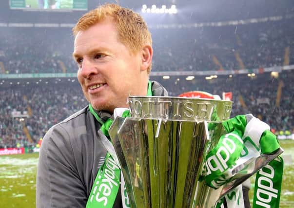 Neil Lennon hugs the trophy which Celtic won for an eighth consecutive time. Picture: PA.