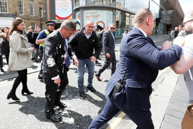 Brexit Party leader Nigel gestures after being hit with a milkshake while arriving for a Brexit Party campaign event in Newcastle