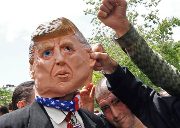 Iranian protestors gesture towards a man in a Donald Trump mask during a demonstration in Tehran. Picture: Getty