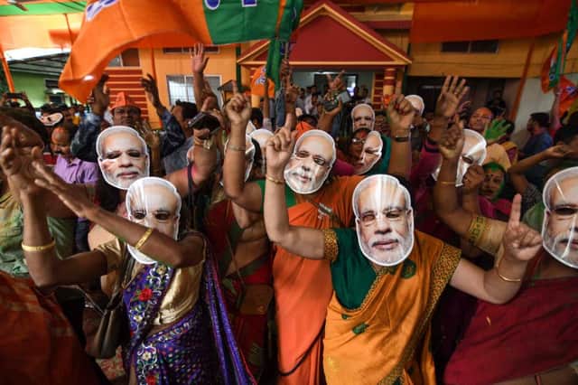 Indian Bharatiya Janata Party (BJP) supporters wearing masks of Indian Prime Minister Narendra Modi dance as they celebrate on the vote results day for India's general election. BIJU BORO/AFP/Getty Images
