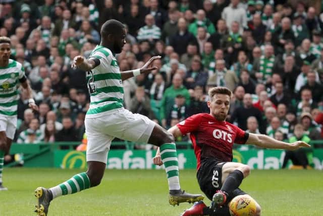 Stephen O'Donnell slides in on Odsonne Edouard during a clash at Celtic Park.