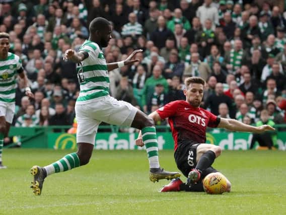 Stephen O'Donnell slides in on Odsonne Edouard during a clash at Celtic Park.