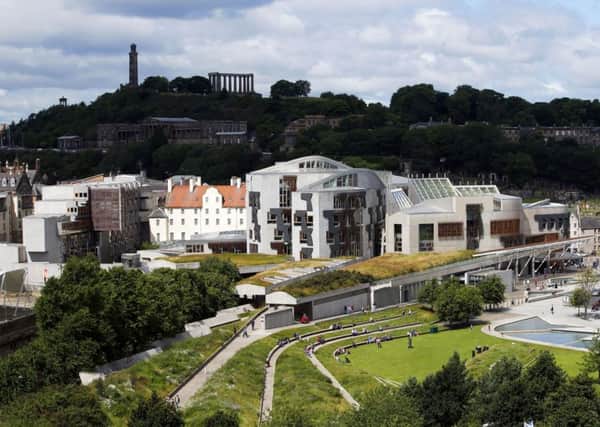 The Scottish Parliament lies below the National Monument of Scotland, based on the Parthenon in Athens (Picture: Jane Barlow/PA Wire)