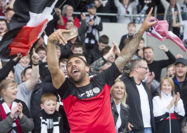 Anton Ferdinand takes a selfie while celebrating with the St Mirren fans after the Paisley clubs play-off victory over Dundee United. Picture: PA.