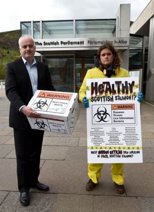 Don Stainford from Scottish Salmon Watch outside the Scottish Parliament handing a petition to Mark Ruskell MSP

. Pic: JPIMedia
