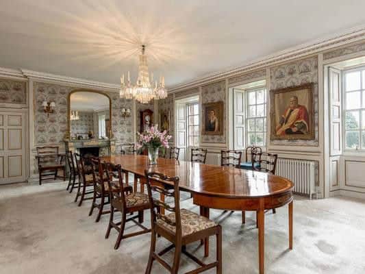 The elegant dining room boasts an ornate fireplace.