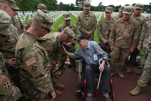 Soldiers of the U.S. Army ask U.S. D-Day veteran Leonard Jindra, 98, about his service following a small ceremony at Normandy American Cemetery. Picture: Getty