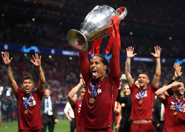 Virgil Van Dijk sticks his tongue out as he lifts the Champions League trophy. Picture: Getty.