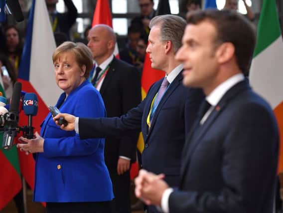Germany's Chancellor Angela Merkel and French President Emmanuel Macron speak to the media ahead of a European Council meeting on Brexit in Brussels.