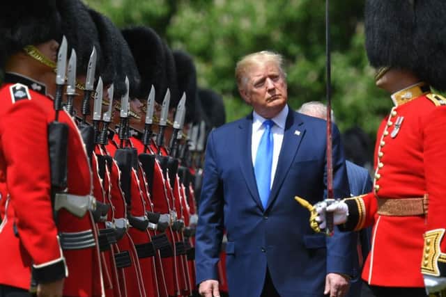 US President Donald Trump inspects an honour guard during a welcome ceremony at Buckingham Palace. Photo by MANDEL NGAN / AFP