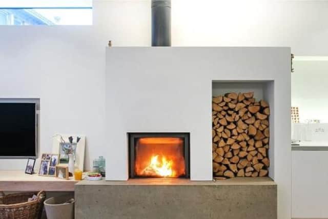 The living room has a statement wood burning stove and log storage space.